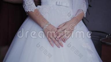 新娘`早上。 新娘特写的手躺在白色婚纱上。 穿白色婚纱的漂亮新娘。